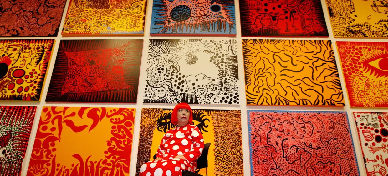Yayoi Kusama poses for a photograph with her artwork 'Love Arrives At The Earth Carrying With It A Tale Of The Cosmos' at the Tate Modern gallery in London in February 2012. Photo: Reuters 