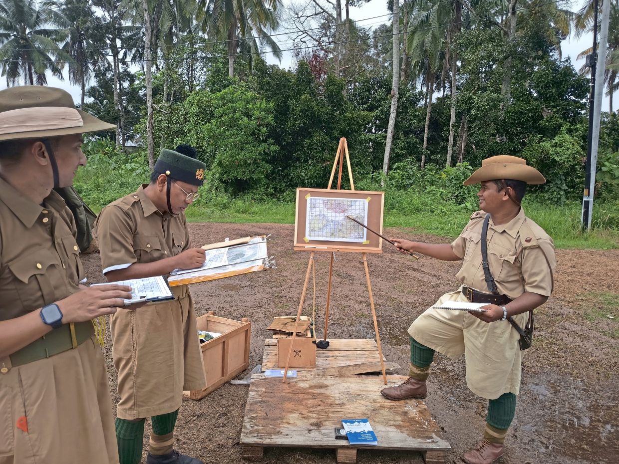 Abdul Hakim (right) teaching map reading skills during a recent re-enactment jamboree. Photo: Persatuan Reka Ulang Sejarah