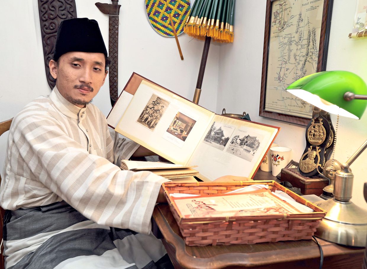Showing off his collection of old photographs, Mohamad Alif recalls how influential his late grandmother was on his love for history. Photo: The Star/Chan Tak Kong