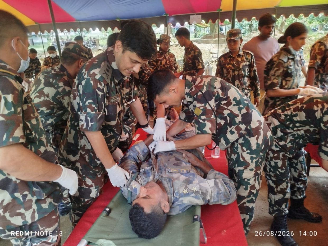 Nepali army soldiers administer first aid to a survivor following flash floods and a mudslide near the Nepal-Tibet border in Nepal, in this handout image obtained on Aug 27, 2026. - Photo: Nepali Army/Handout via Reuters