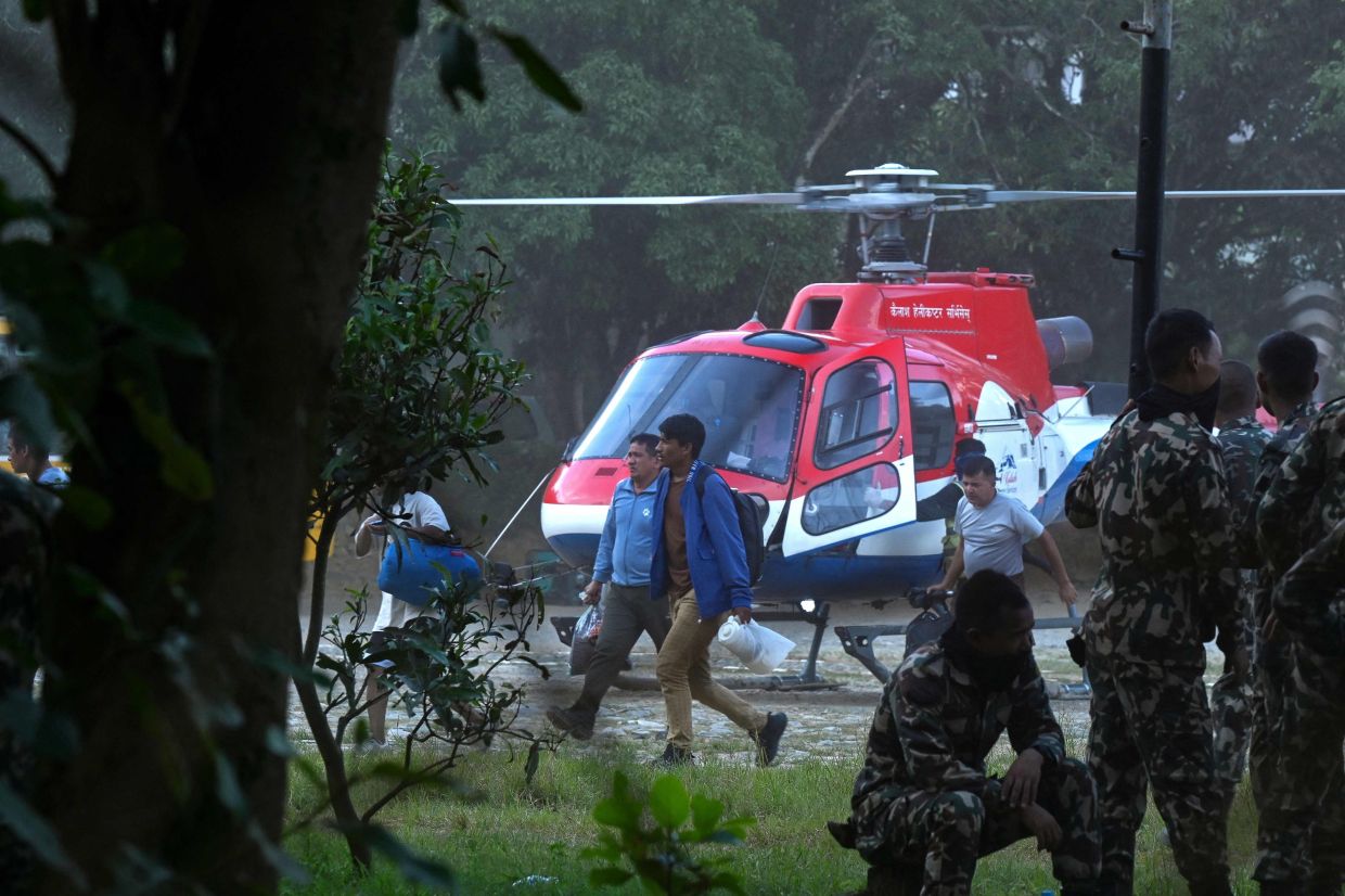 Rescued residents disembark a helicopter at an army camp following flash floods, in Battar Bazar town of Nepal's Nuwakot district on Aug 27, 2026. Rescue teams rushed on Aug 27 to find more than 1,400 people missing on the Nepal-Tibet border in flash floods and landslides that killed at least 362 and swept away entire villages. - Photo: AFP