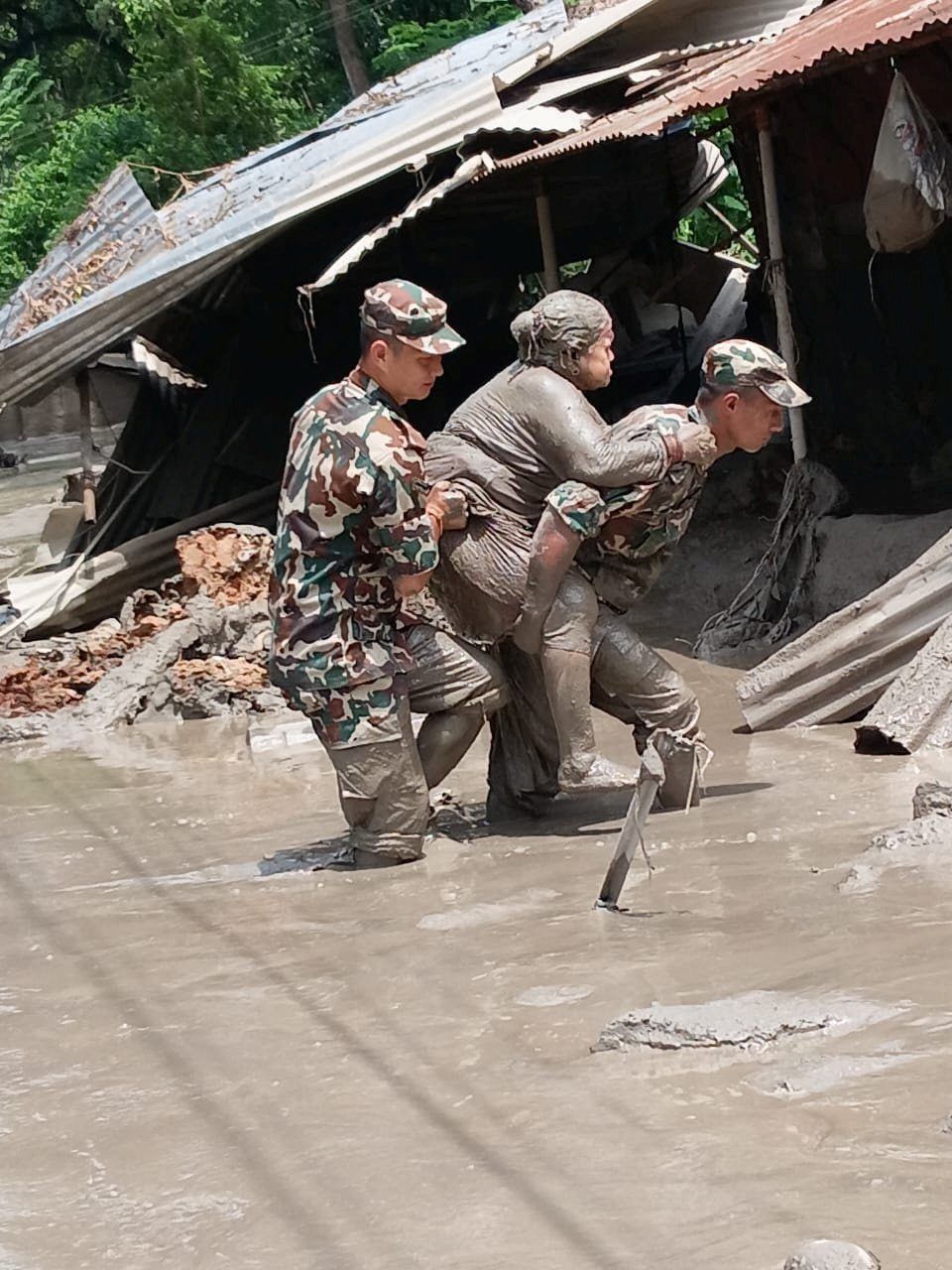 Nepali army soldiers move a survivor following flash floods and a mudslide near the Nepal-Tibet border in Nepal, in this handout image obtained on August 27, 2026. Nepali Army/Handout via REUTERSATTENTION EDITORS - THIS IMAGE HAS BEEN SUPPLIED BY A THIRD PARTY. MANDATORY CREDIT. NO RESALES. NO ARCHIVES.