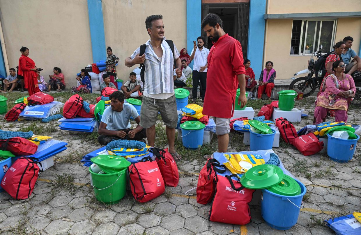 Residents gather to receive utility aid at a hospital turned temporary shelter after flash floods in the Devighat area of Nepal's Nuwakot district on August 27, 2026. Rescue teams scoured devastated zones August 27 for more than 1,400 people missing a day after flash floods and landslides along the Nepal-Tibet border. - Photo: AFP