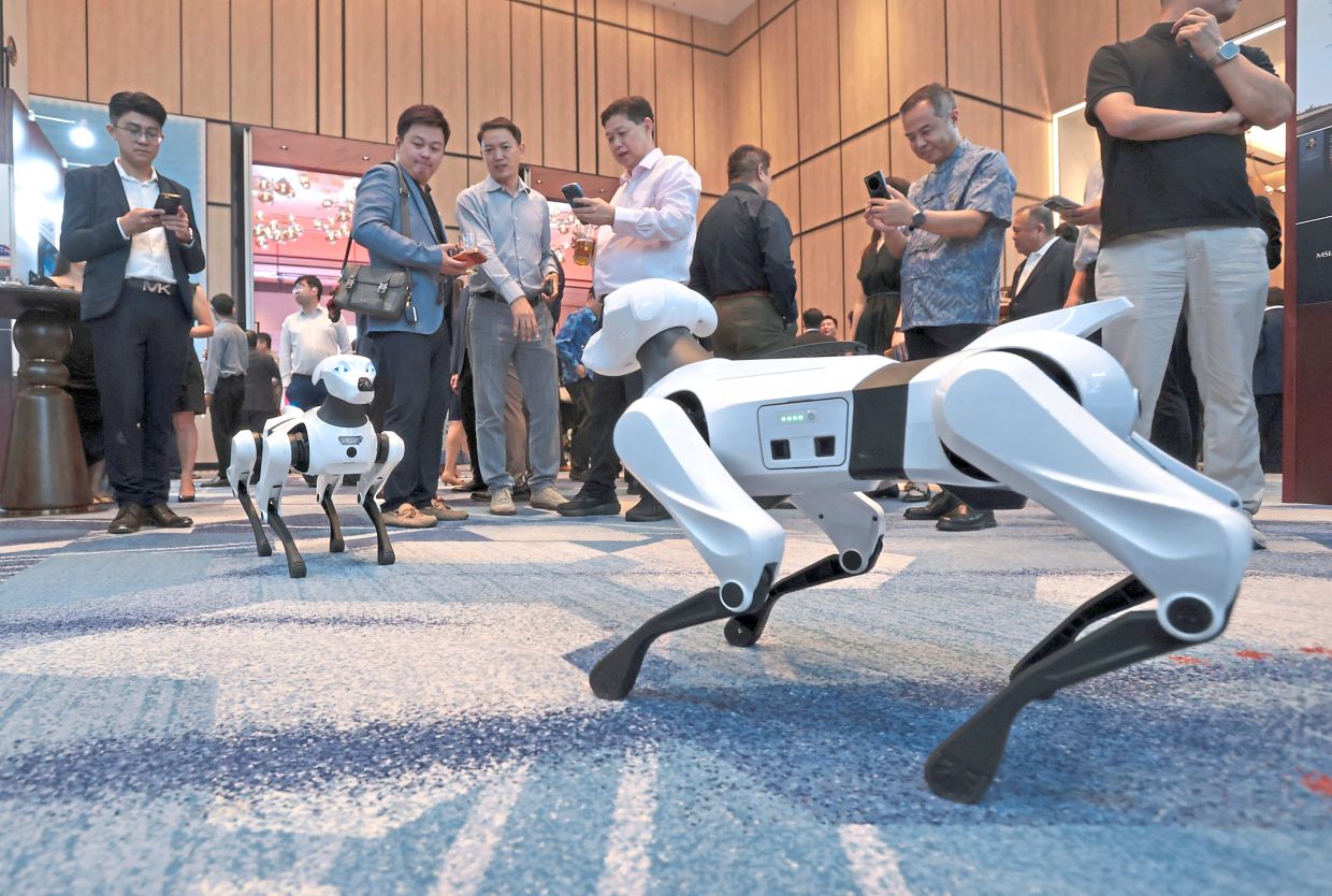 Guests at the MSIA fifth anniversary and Merdeka celebration dinner checking out the capabilities of AI-powered robotic canines.