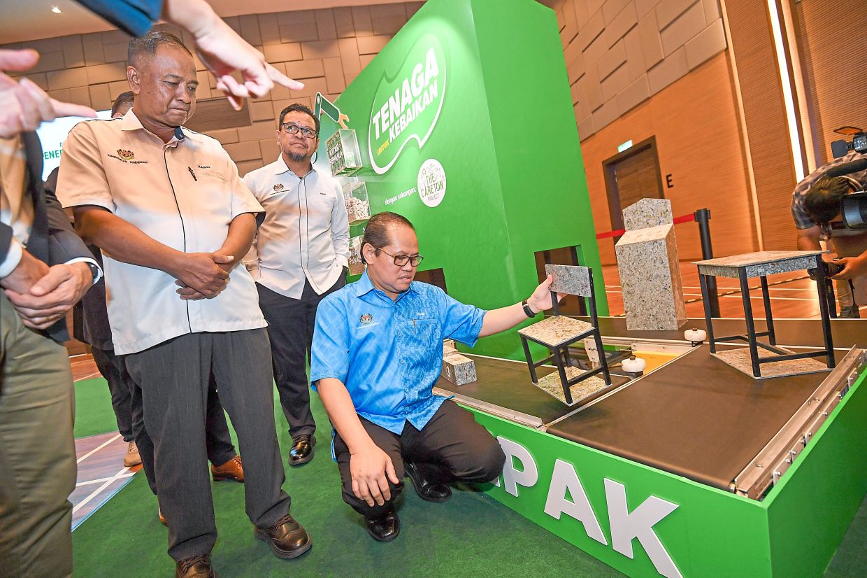 Mohd Azam taking a look at the polyAl tables and chairs made from recycled UBCs.