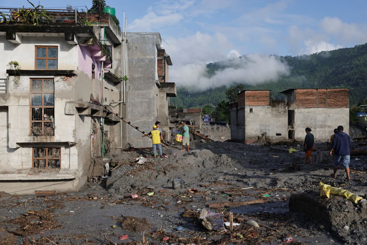 People workING to clear the debris around their houses Trishuli. - Reuters