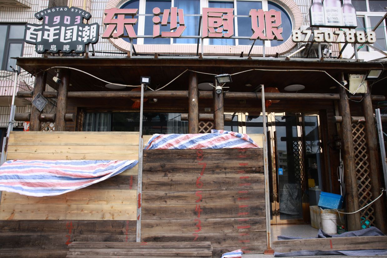 Flood barriers stand outside a shop, along the coast in Yuhuan, where Typhoon Bavi and Typhoon Dolphin made landfall, as Typhoon Saudel approaches Zhejiang province, China on Aug 27, 2026. - cnsphoto via Reuters