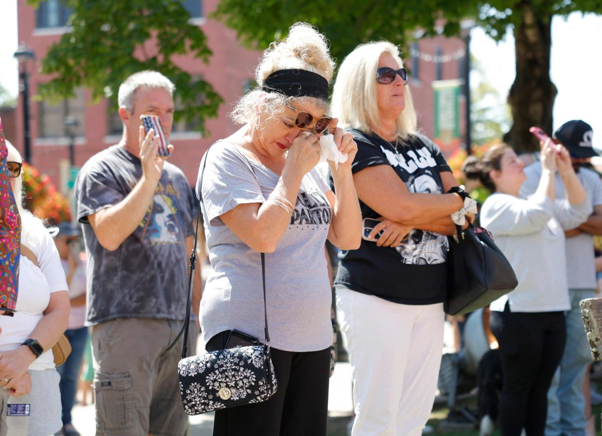 Dolly Parton fans attend a moment of silence at The Dolly Parton Statue on the front lawn of the Sevier County Courthouse on August 25, 2026 in Sevierville, Tennessee. Photo: AFP
