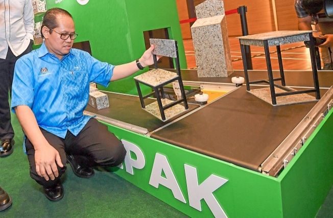 Mohd Azam taking a look at the polyAl tables and chairs made from recycled UBCs.