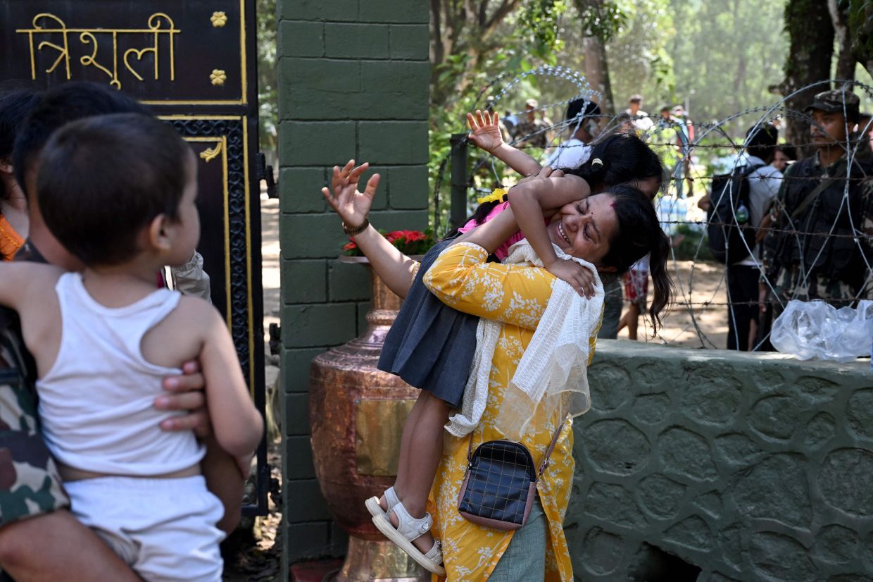 A woman embraces her child following their rescue from a flash flood site at Trishuli camp in Nepal's Nuwakot district on Aug 28, 2026. - AFP