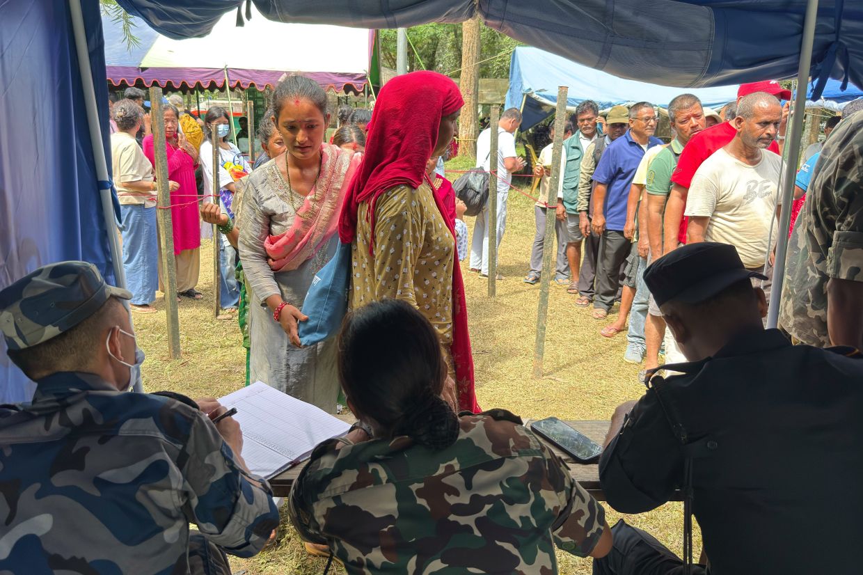 People rescued from an area cut off by flash flooding lining up to register at an army camp in Nepal's Nuwakot district on Aug 28, 2026. - AP