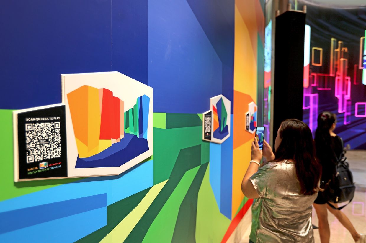 Visitors can create their own artworks using Augmented Reality (AR) features accessible through their mobile phones. Photo: The Star/Chan Tak Kong