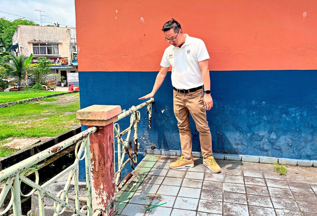 Puah looking at the rusty and damaged hand rails at the Puteri Wangsa food court.