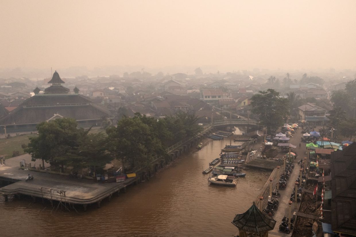 A drone view of boats in the Kapuas River as haze from wildfires blankets the area in Pontianak, West Kalimantan province, Indonesia, on Friday, August 28, 2026. -- Photo: REUTERS/Willy Kurniawan