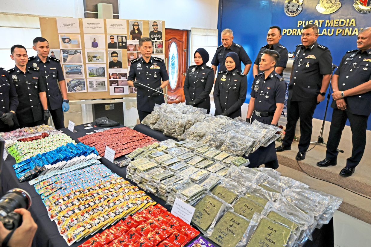 Major haul: Comm Lim (third from left) pointing at some of the drugs seized during the raids. — LIM BENG TATT/The Star