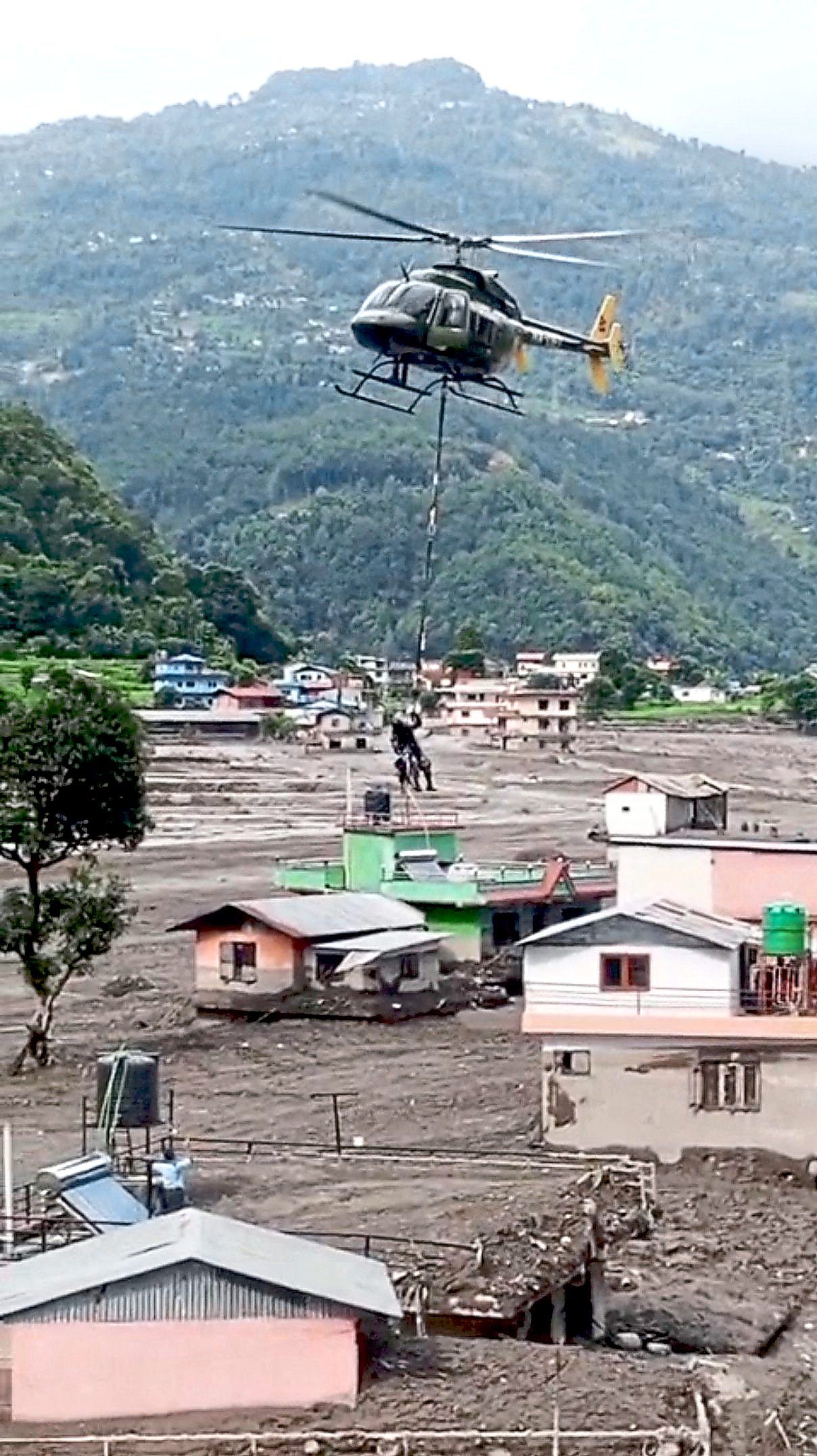 Search and rescue: A Nepal Army helicopter flying over houses as they rescue stranded people at an undisclosed location, following flash floods and a mudslide, in Nepal. — Reuters
