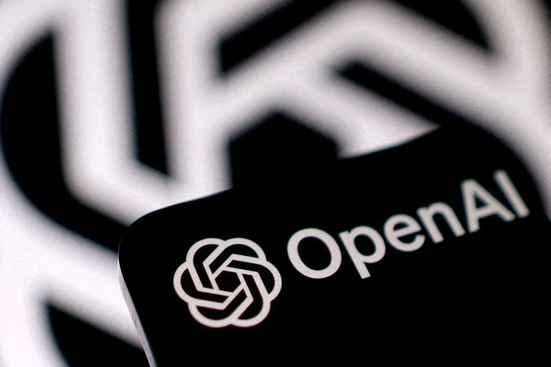 OpenAI logo on a phone screen in front of a large blurred OpenAI logo