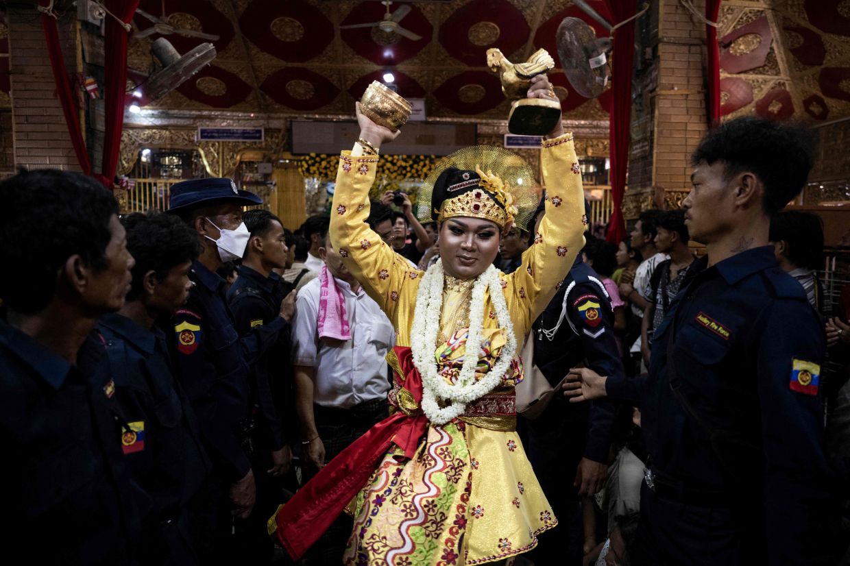 A spirit medium performing a ritual dance during the Taungbyone Spirit Festival. - AFP