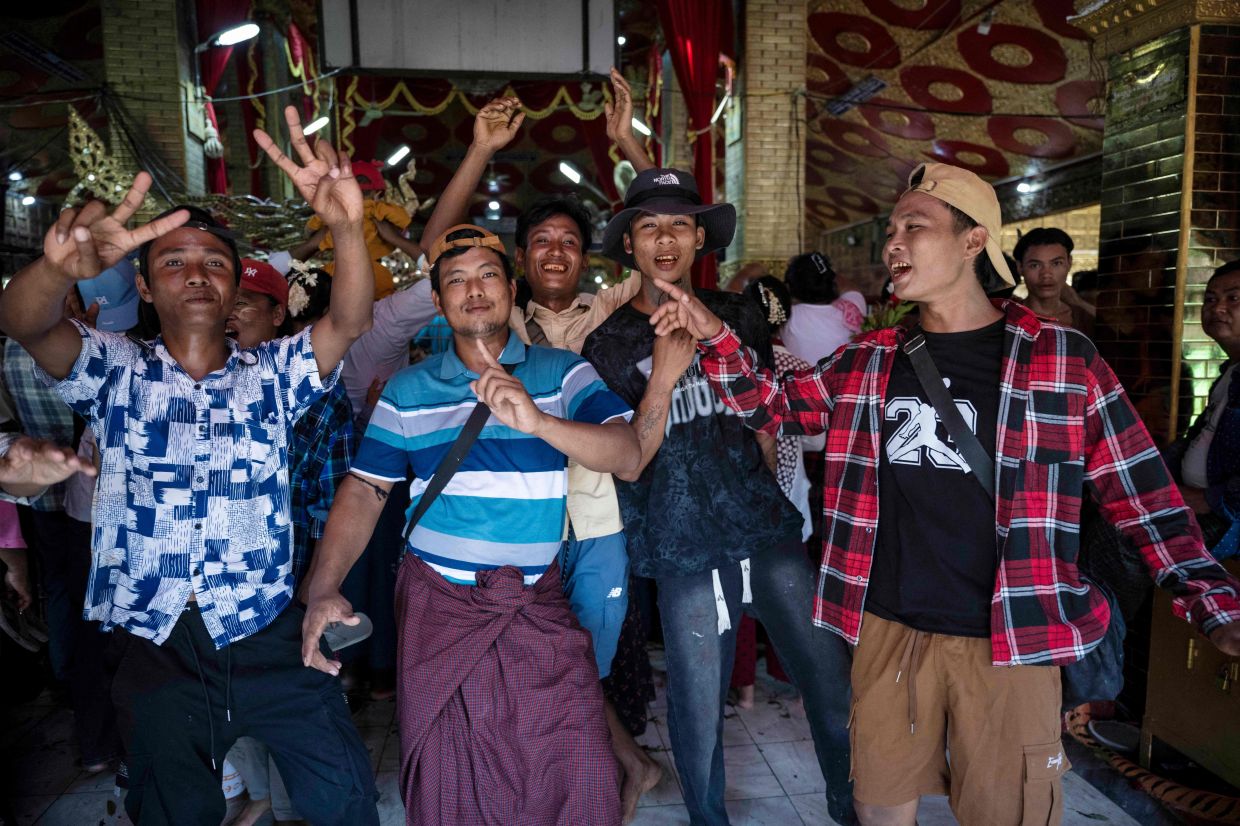 Men dance and celebrate the annual Taungbyone Spirit Festival in Madaya. - AFP