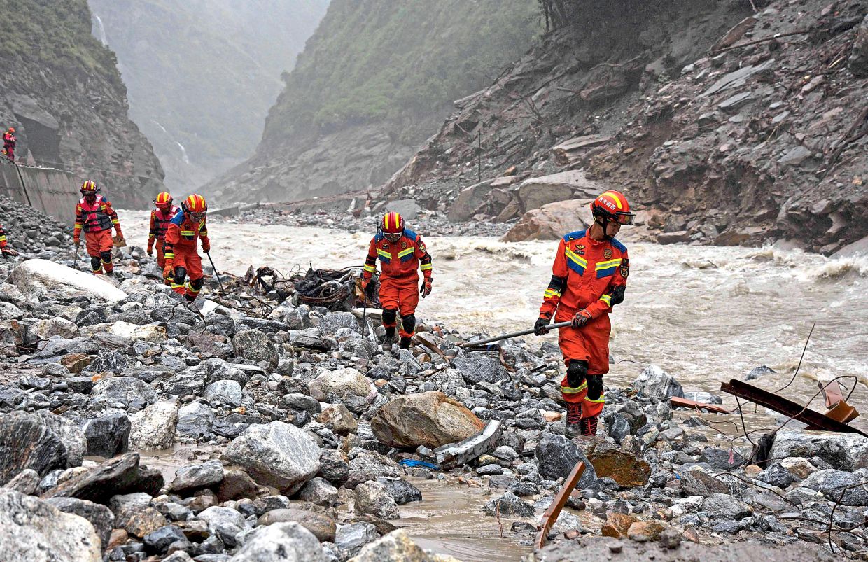 No stone unturned: Fire and rescue personnel conducting searches 2km from Gyirong Port in China’s western Tibet region. — AFP