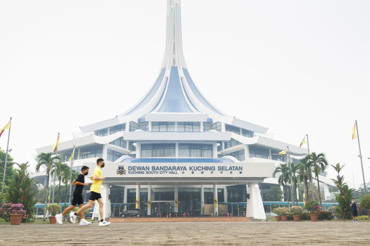 Members of the public continue their morning jog in front of the Dewan Bandaraya Kuching Selatan (MBKS) headquarters despite thick haze blanketing the city at 7am. Kuching recorded an Air Pollutant Index (API) reading of 284, while Serian hit 358, as worsening air quality continued to affect parts of Sarawak. The public has been advised to reduce outdoor activities and wear protective masks. — ZULAZHAR SHEBLEE/The Star