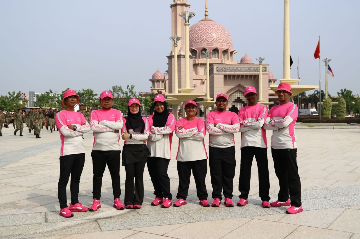 foodpanda deliver partners celebrating the nation together. (From left) Khairul Jefri, Duwey, Awan, Azizah, Casey Chuan, Danny Raman, Gopinath and Zul Lukman.