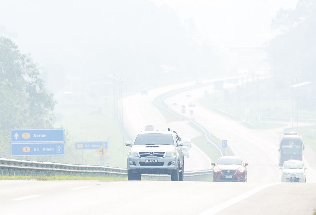 Vehicles move cautiously along the Pan Borneo Highway near Serian as thick haze severely reduces visibility at 11am on Sunday. Serian recorded an Air Pollutant Index (API) of 401, classified as hazardous, while Samarahan stood at 325 and Kuching at 299. Motorists are advised to drive carefully as landmarks and vehicles become increasingly obscured by the dense haze. — ZULAZHAR SHEBLEE / The Star