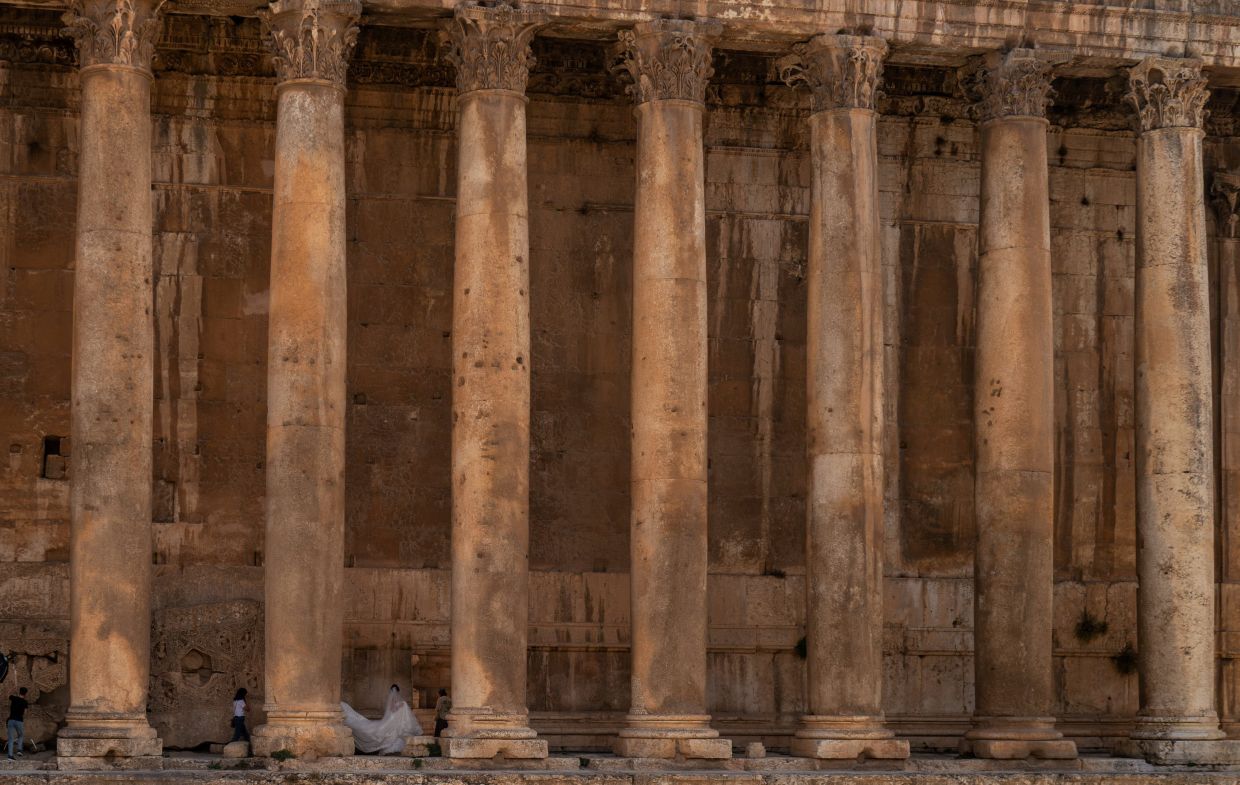 A Lebanese bride walks among the columns of the Roman Temple of Bacchus during a wedding photo shoot in the historic town of Baalbek, Lebanon. Photo: Reuters 