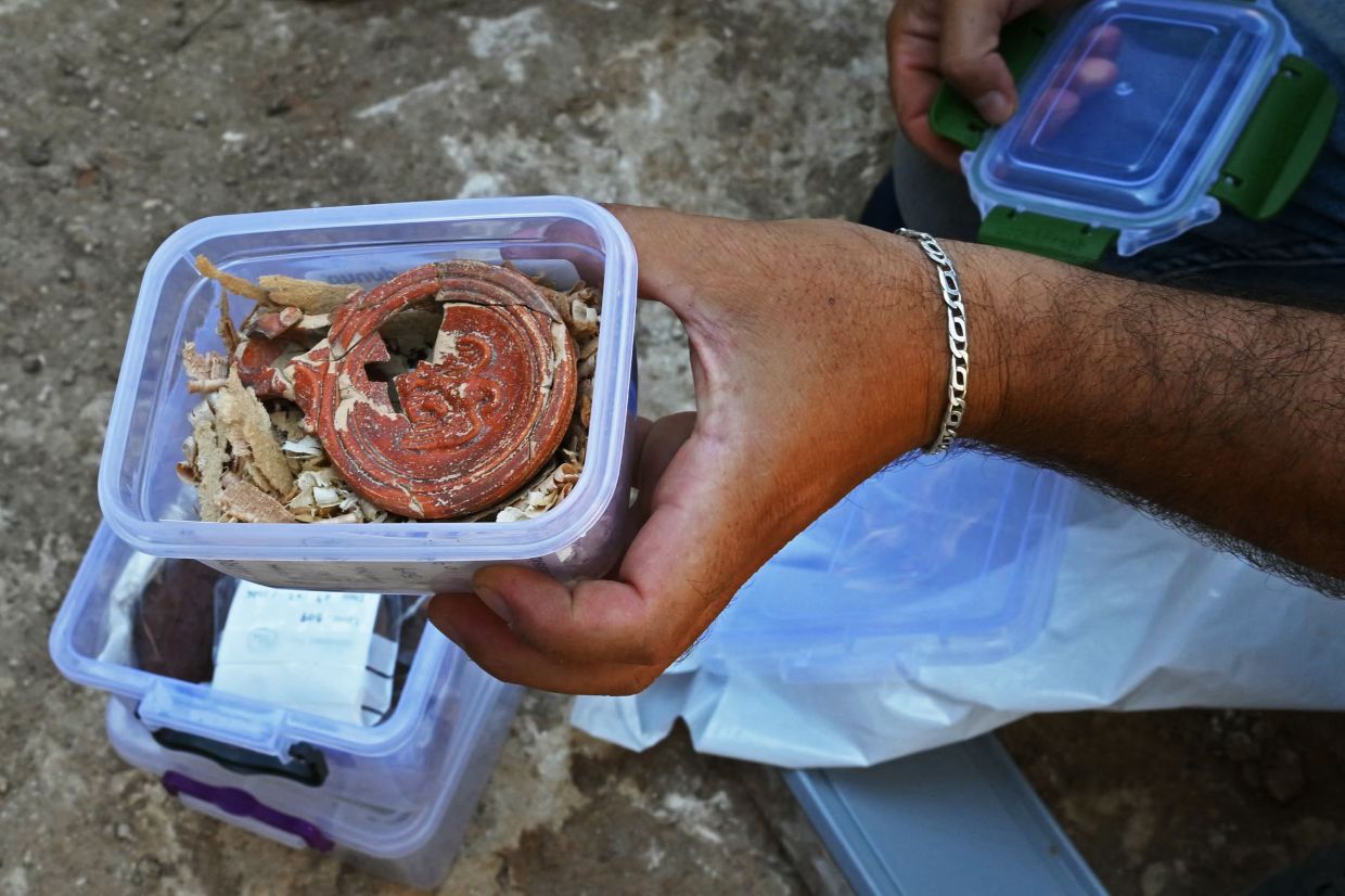 An archaeologist displays an artefact found at a site in Batroun, northern Lebanon. Photo: AFP