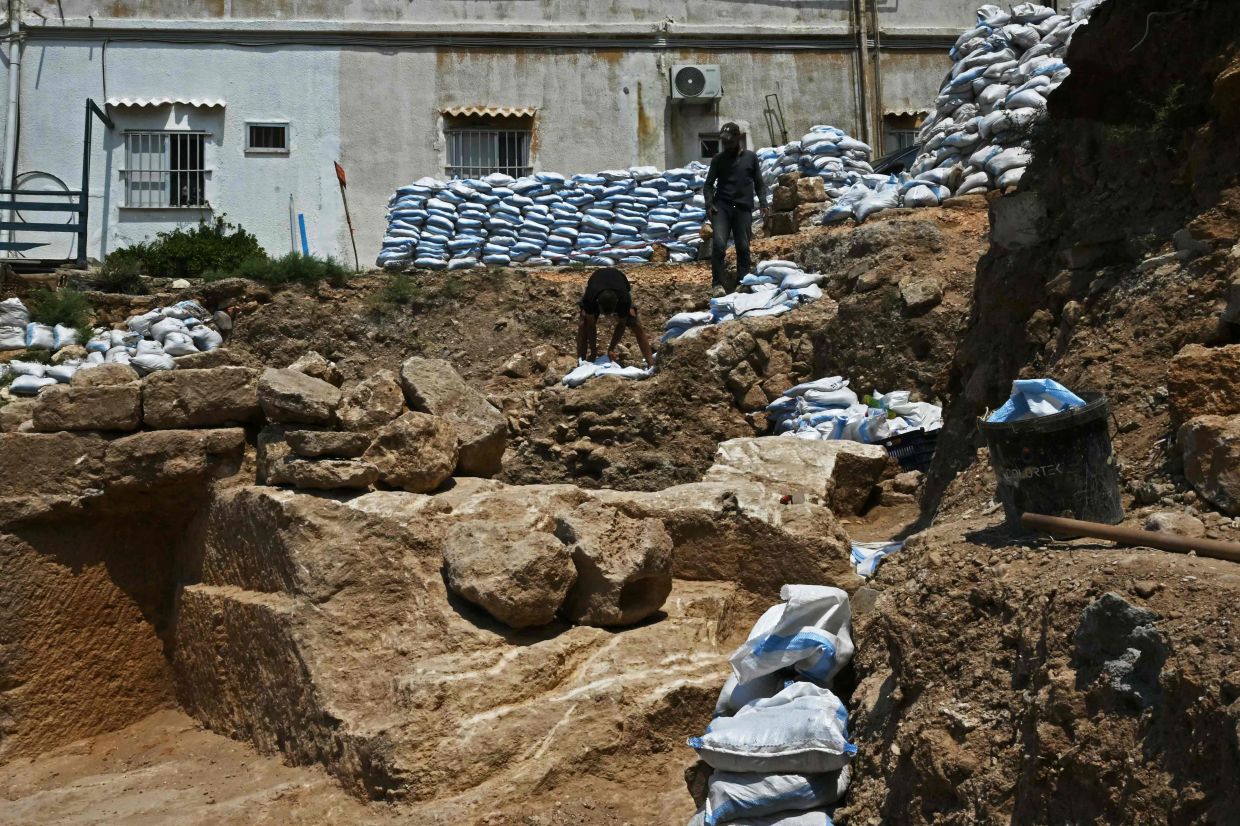 Members from the team of archaeologists lay protective sand bags at an archaeological site in the northern coastal Lebanese town of Batroun. Photo: AFP