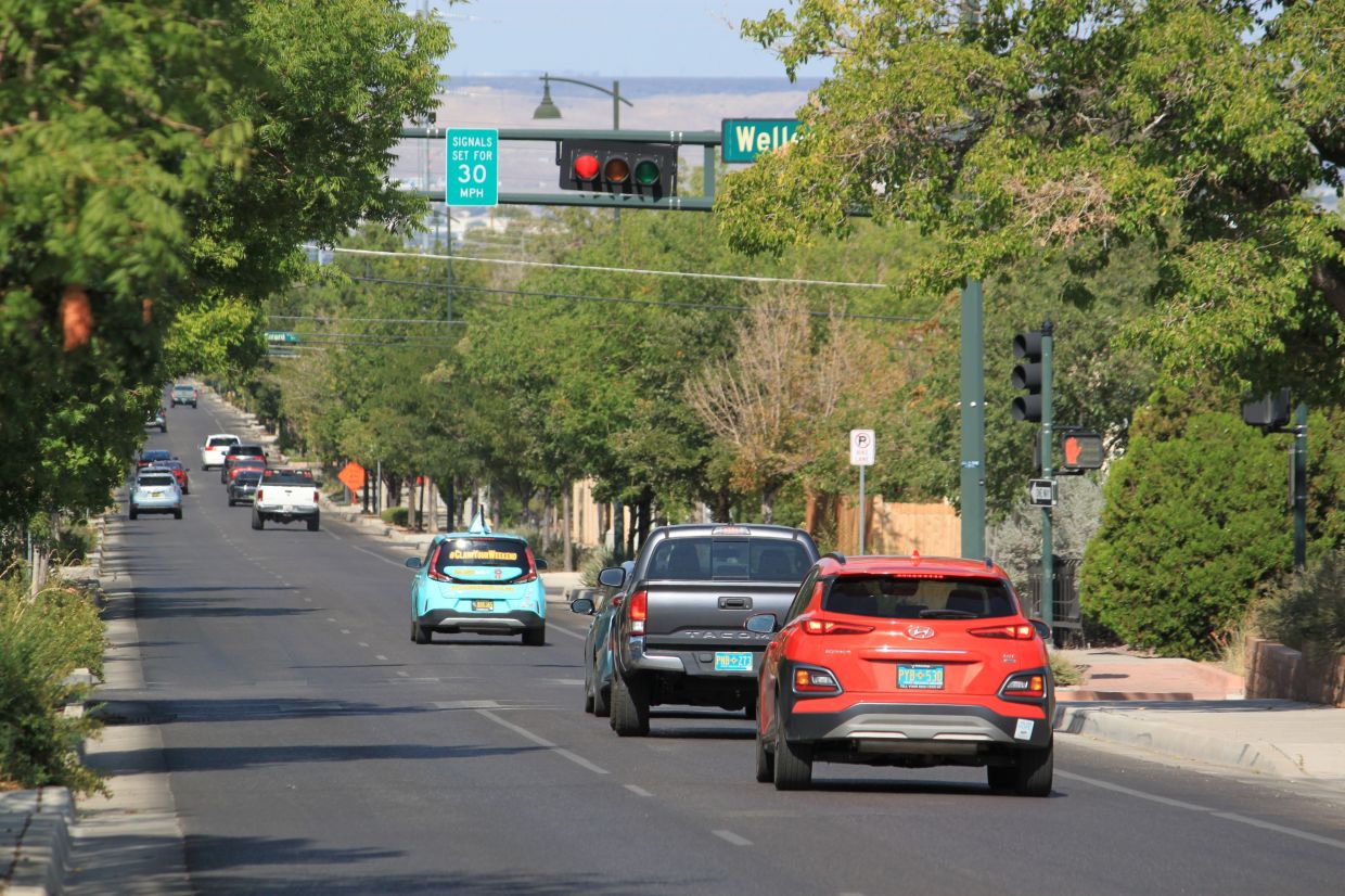 Vehicles stop along Lead Avenue where stoplights are set for a specific speed limit as part of the 'rest on red' signal program in Albuquerque.