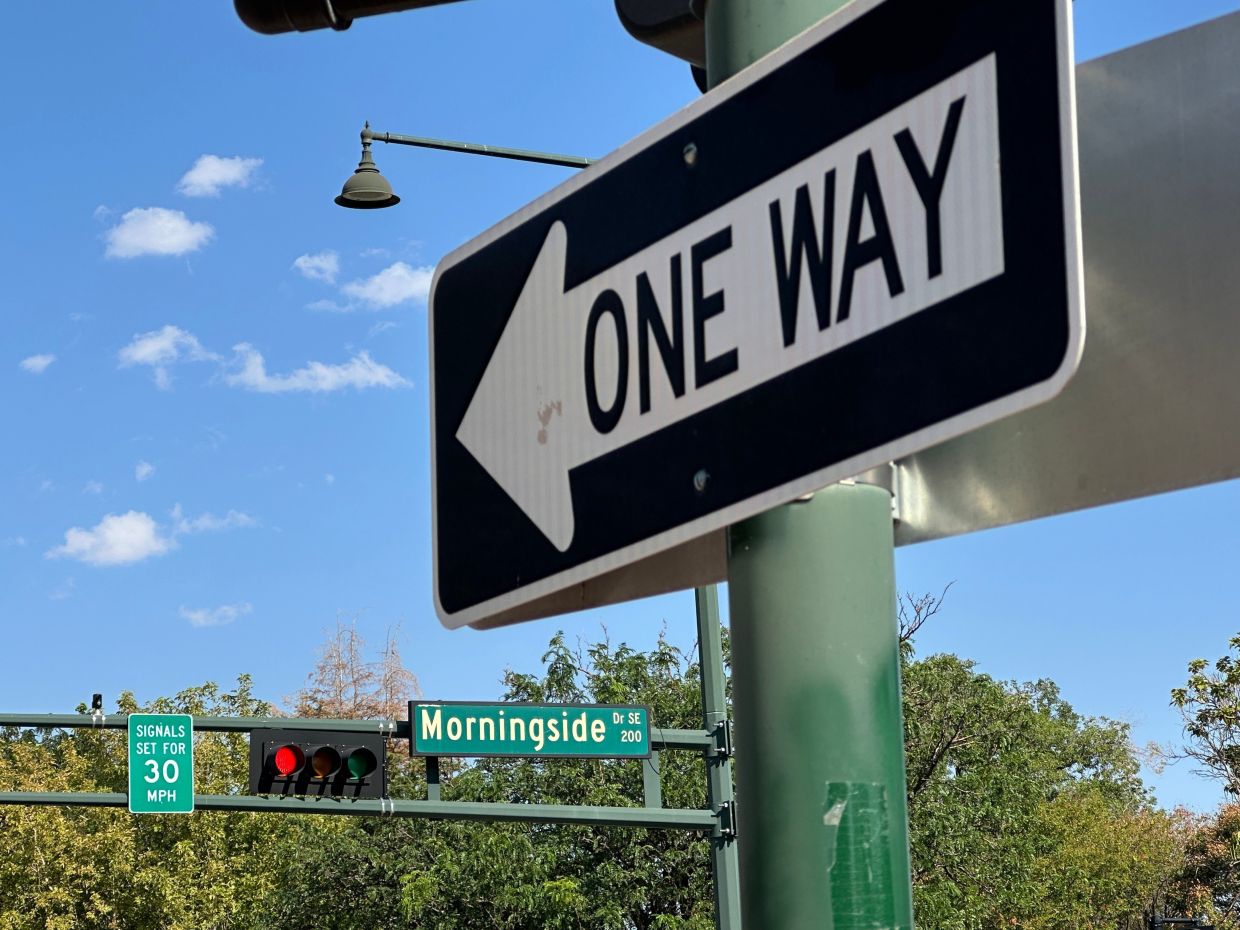 A sign notifies drivers that stoplights are set for a specific speed limit as part of the 'rest on red' signal program in Albuquerque.