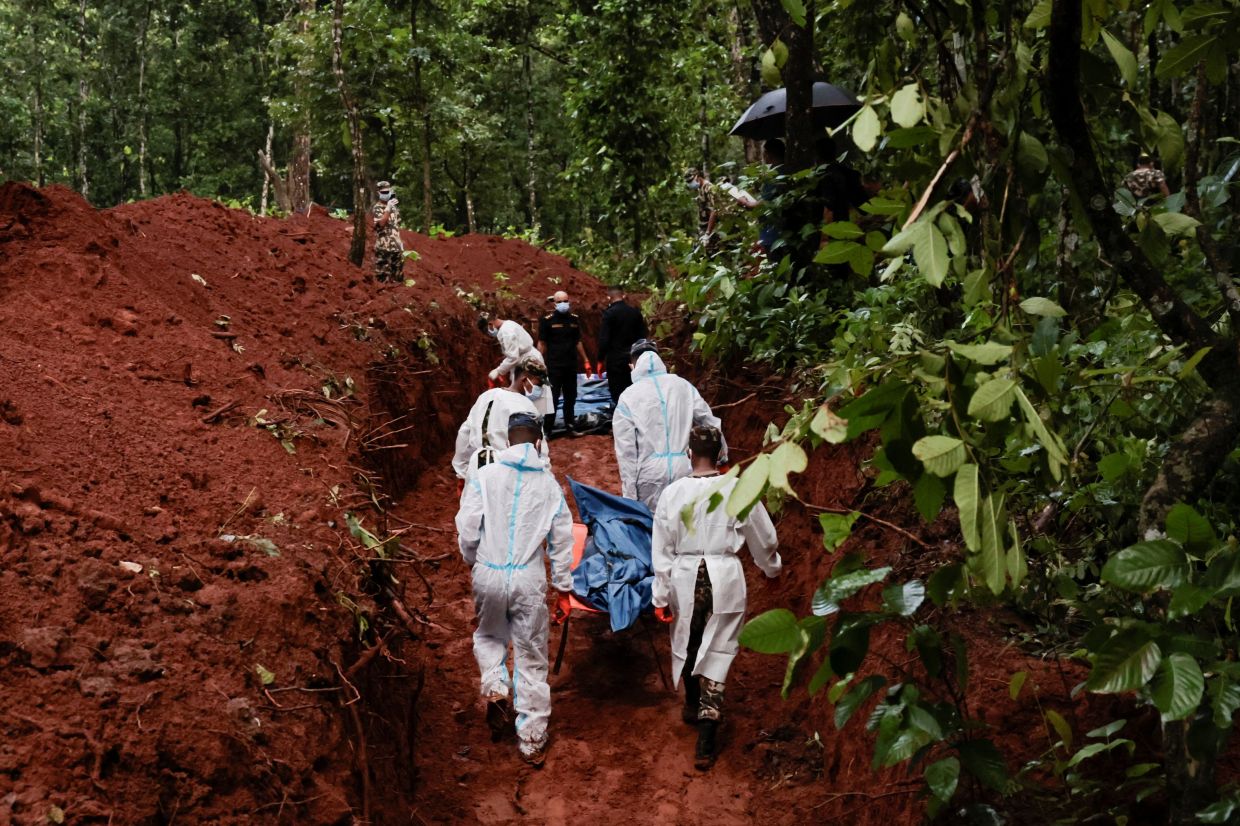 Armed Police Force (APF) officers work on transporting bodies to the pit at Devghat mass burial site for victims of deadly flash floods and mudslides in Chitwan, Nepal, August 30, 2026. REUTERS/Navesh Chitrakar REFILE - QUALITY REPEAT