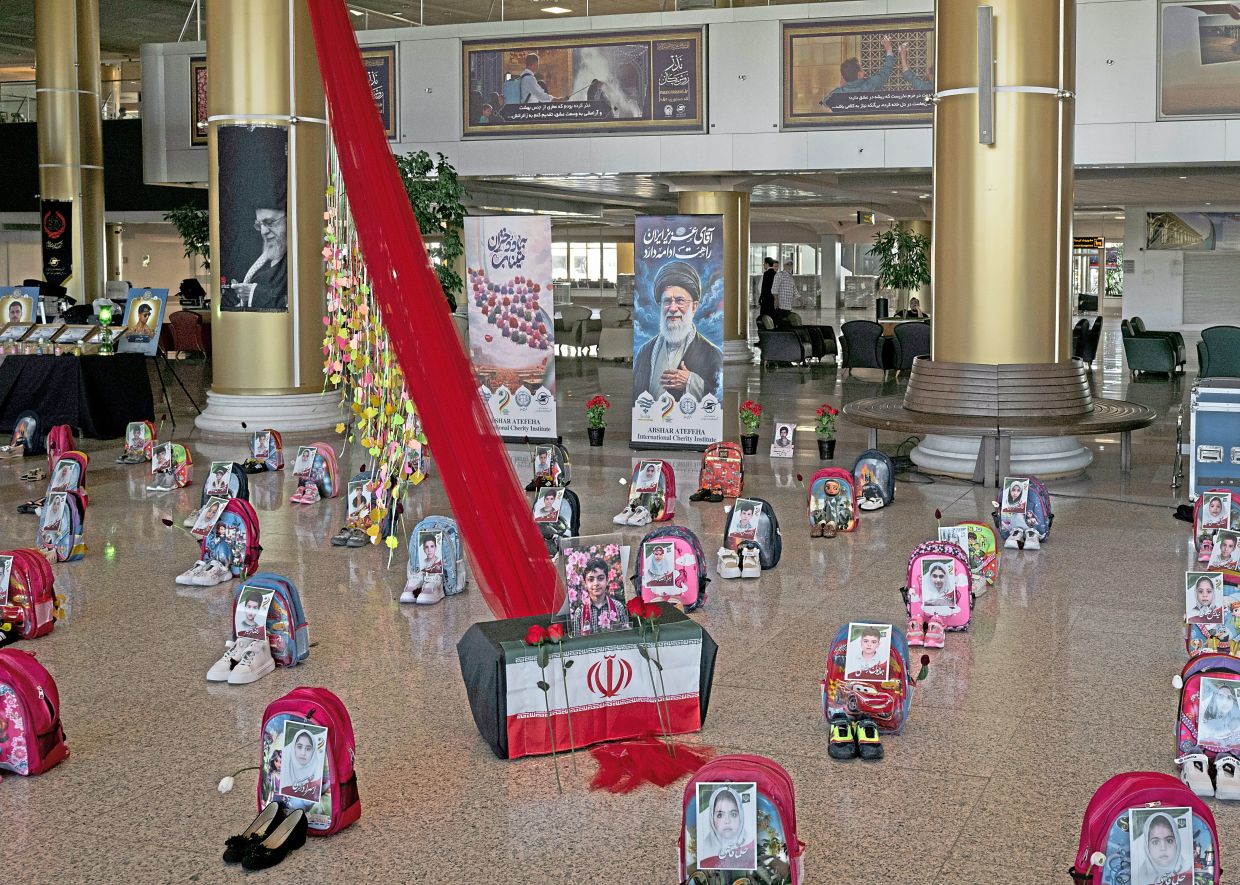 A display commemorating the deaths of children killed in an airstrike on an elementary school is seen on July 8, 2026, at the airport in Mashad, Iran. — Emile Ducke/The New York Times