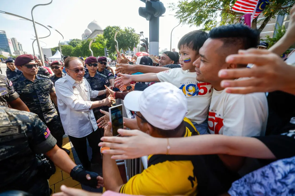 PM Anwar surprises National Day spectators by mingling with them after parade; over 100,000 attended, says Fahmi