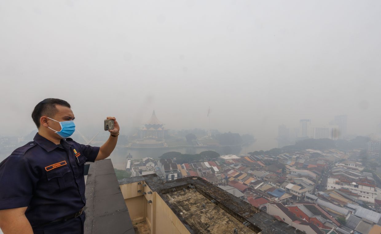 Hotel security guard Edwin Abraham recording the hazy conditions over Kuching city to report the situation to the hotel management on Monday (Aug 31). Kuching recorded an unhealthy Air Pollutant Index (API) reading of 349 at 1pm, one of four areas in Sarawak with very unhealthy API levels. The others were Serian (456), Sri Aman (331) and Samarahan (336). — ZULAZHAR SHEBLEE/The Star