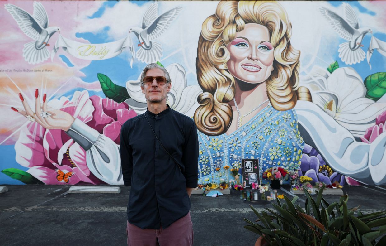 Artist David Gilmore stands in front of a mural he made of the late Dolly Parton, as people attend a candlelight vigil in her honour, in Costa Mesa, California. Photo: Reuters