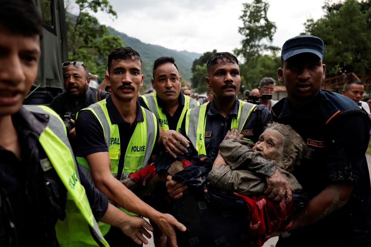 Police officers carry a survivor to a safer place following a flash flood at Devighat in Nuwakot district, Nepal, August 26, 2026. -- Photo: REUTERS/Navesh Chitrakar 