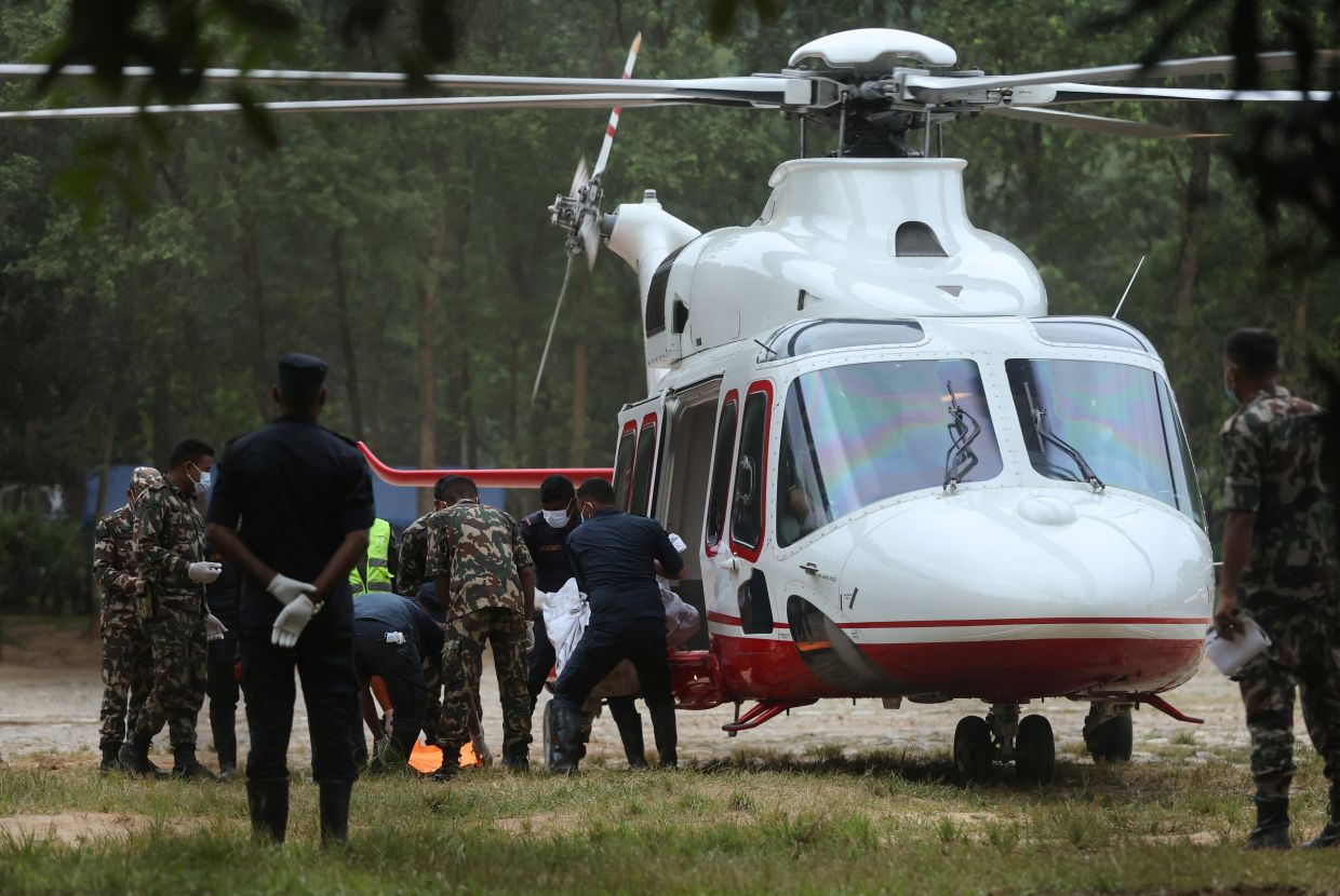 A body is moved into a helicopter by police and army officials after it was airlifted from a landslide-affected area, at the Maithili Barrack, an army training center, following flash floods and a mudslide in Trishuli, Nuwakot district, Nepal, on Monday, August 31, 2026. -- Photo: REUTERS/Francis Mascarenhas
