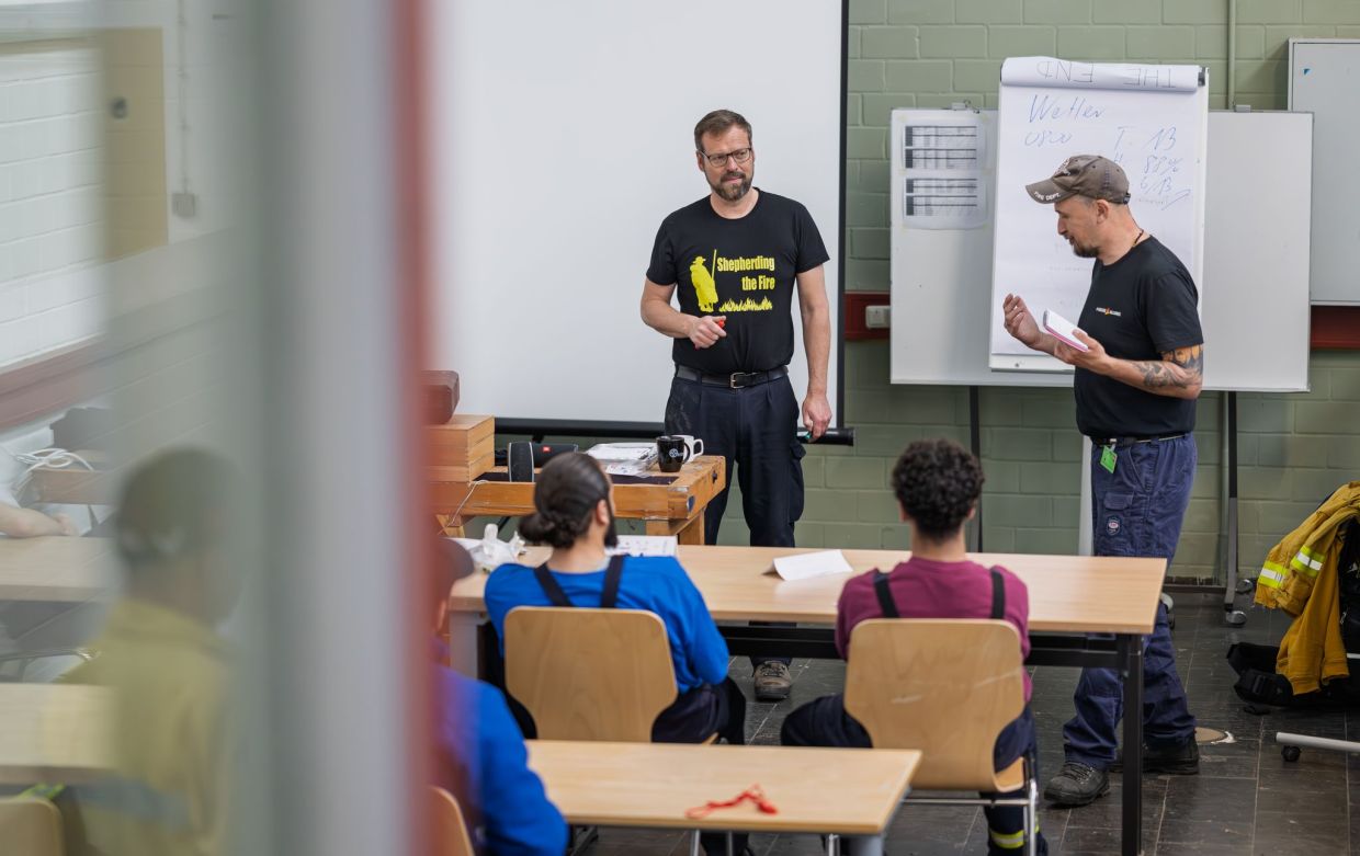 Judge Michael Hermann (l) teaches a class on fighting wildfires at the Hameln youth detention centre. — Philipp Schulze/pyrocene-alliance/dpa