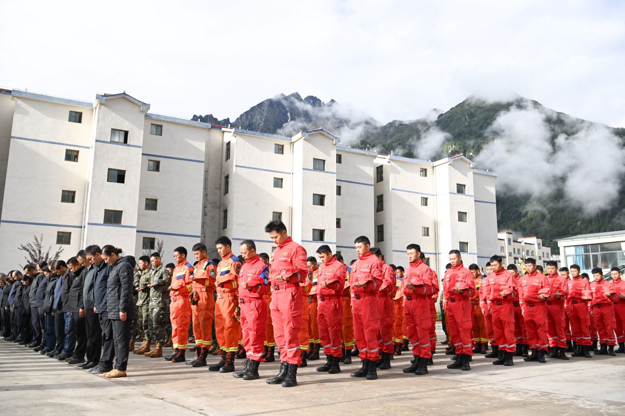 Rescue workers, local officials and residents stand in silence during a memorial service to mourn the victims of the Aug 26 mudslide, in Gyirong county, Shigatse, Tibet Autonomous Region, China, Sept 1, 2026. - Photo: cnsphoto via Reuters