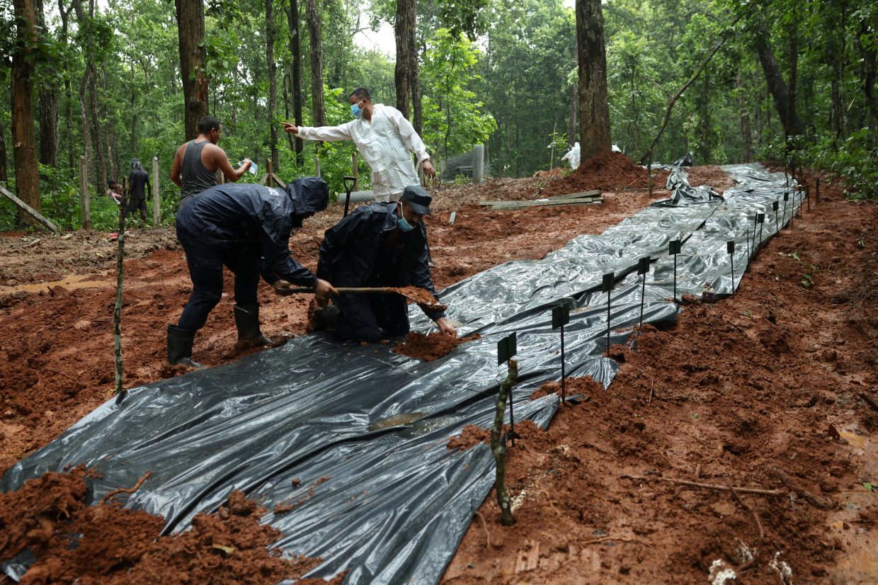 Armed Police Force (APF) officers cover the pit at Devghat mass burial site for victims of deadly flash floods and mudslides in Chitwan, Nepal, on September 1, 2026. Photo: REUTERS/Adnan Abidi 