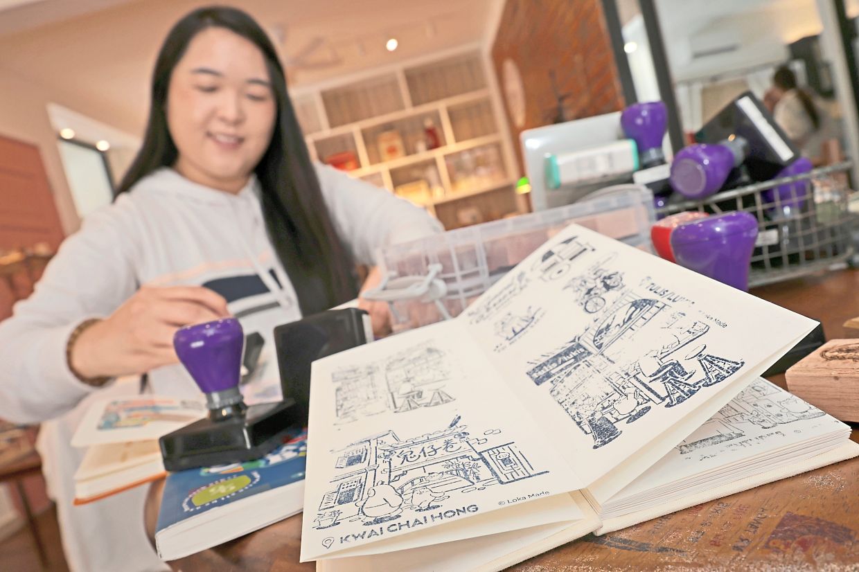 (Right) Loh showing her stamped journal decorated with intricate stamps that depict detailed architectural elements of local heritage sites.