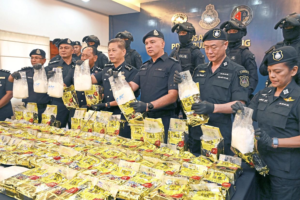 Big haul: Comm Lim (centre) and his police officers showing the seized drugs during a press conference at the northeast district police headquarters in George Town. — KT GOH/The Star