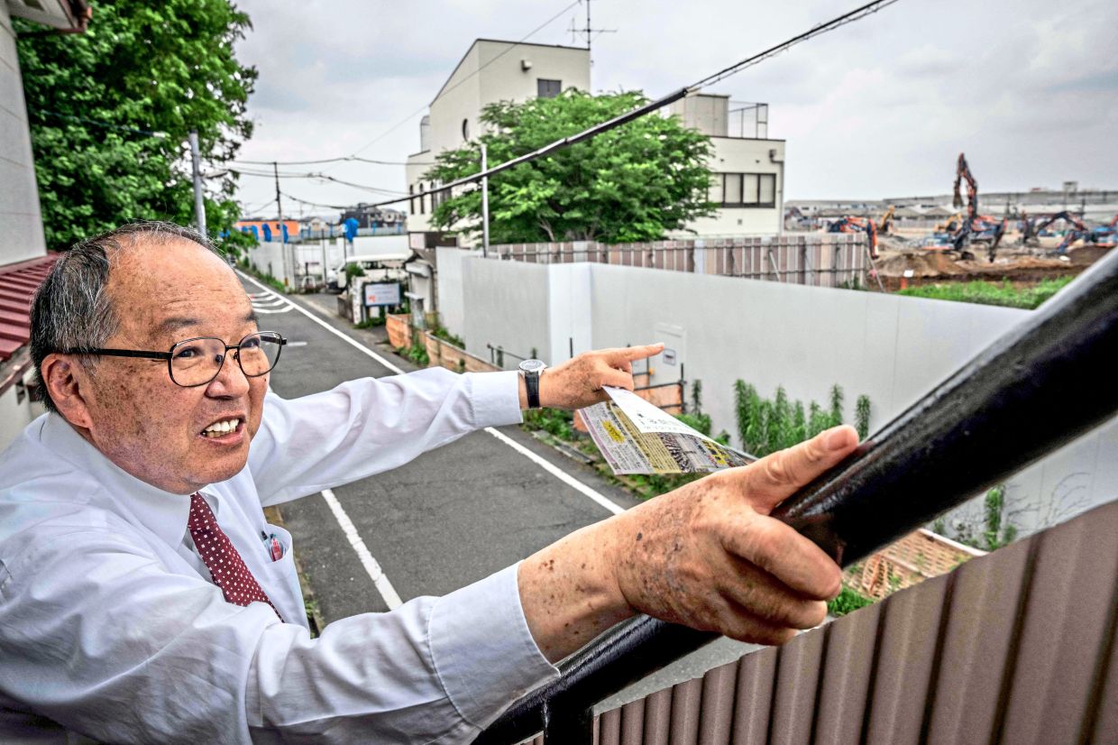 Local resistance: Yamazaki, a representative of a citizens’ group opposing the construction of a data centre, pointing towards the proposed project site in Hino. — AFP