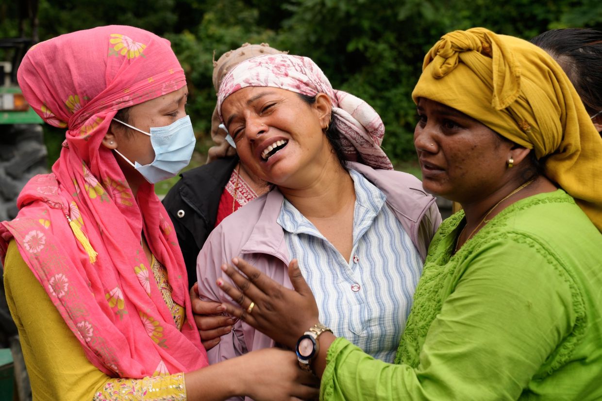 Relatives console Muna Khadka, center, who lost her son Aayush Khadka in flash floods, at a cremation ground in Chitwan, Nepal, Monday, Aug 31, 2026. - Photo: AP