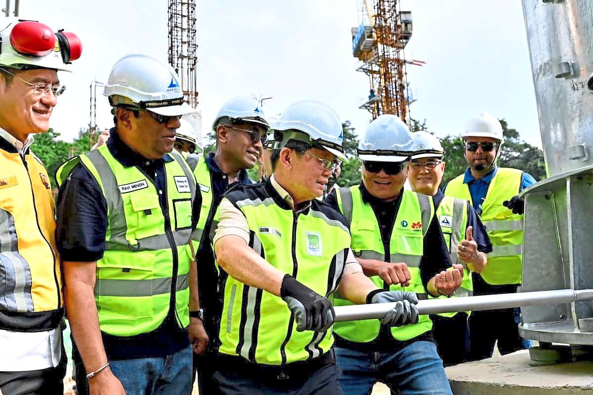 Chow tightening the last bolt of the first tower. Ravindran is on Chow’s right.