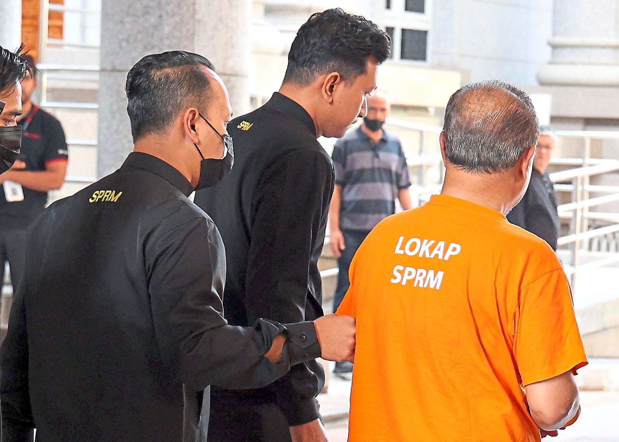 Remanded: The former minister, accompanied by MACC officers, arriving at the Magistrate’s Court in Putrajaya. — MUHAMAD SHAHRIL ROSLI/The Star
