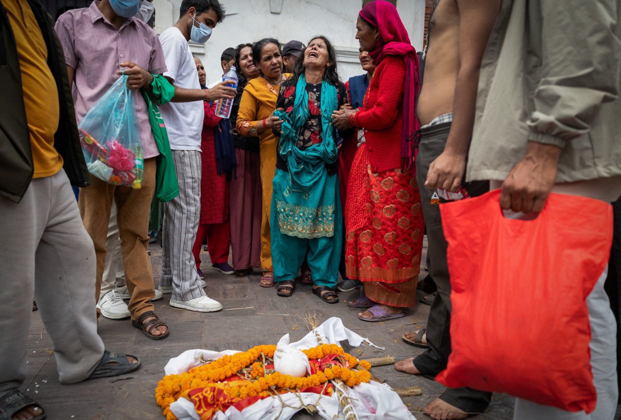 The wife of Bishi Pandey, who lost his life in the deadly flash floods and a mudslide, mourns during his cremation ritual using an effigy as his body remains missing, on the premises of Pashupatinath Temple in Kathmandu, Nepal, Sept 3, 2026. - Photo: Reuters
