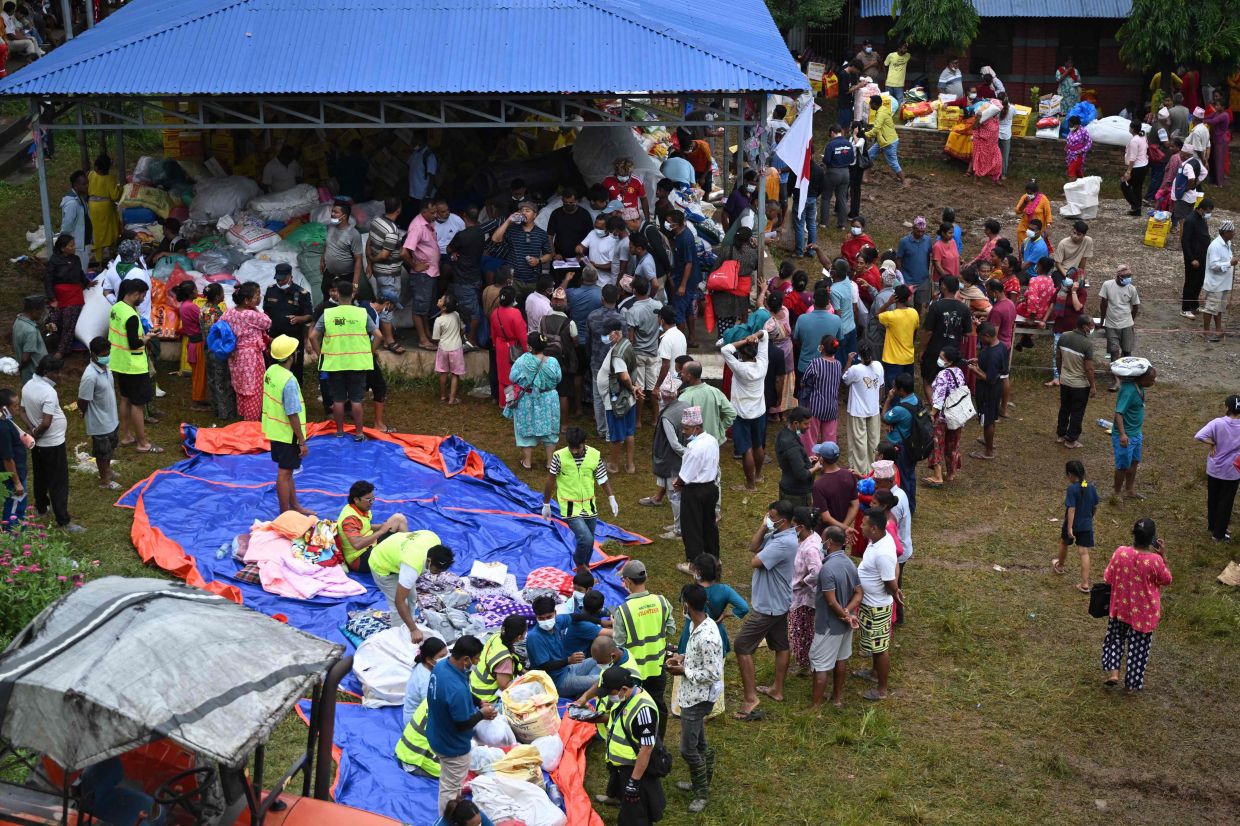 Flash flood survivors gather to receive utility aid from a temporary relief camp at Devighat in Nepal's Nuwakot district on September 3, 2026. Catastrophic floods on the China-Nepal border have killed at least 1,252 people in Nepal, the disaster authority said on Sept 3. - Photo: AFP